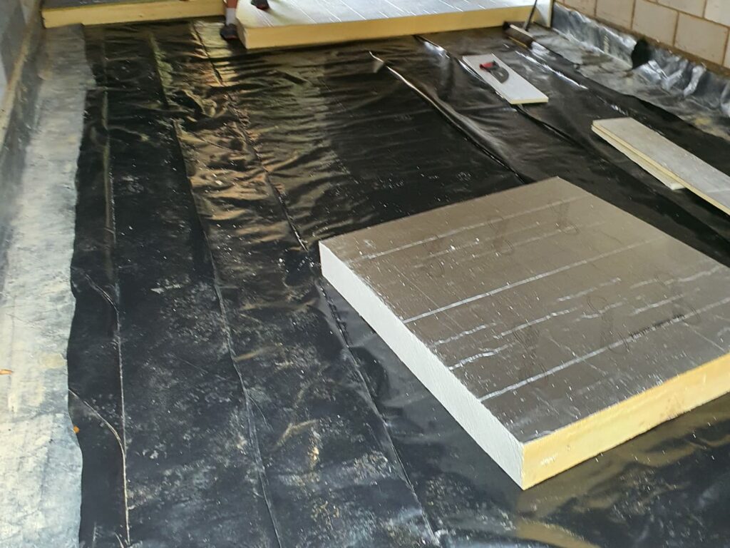 Project story: four new flats in Hampshire, from groundworks to handover Insulation boards going down over the damp-proof membrane