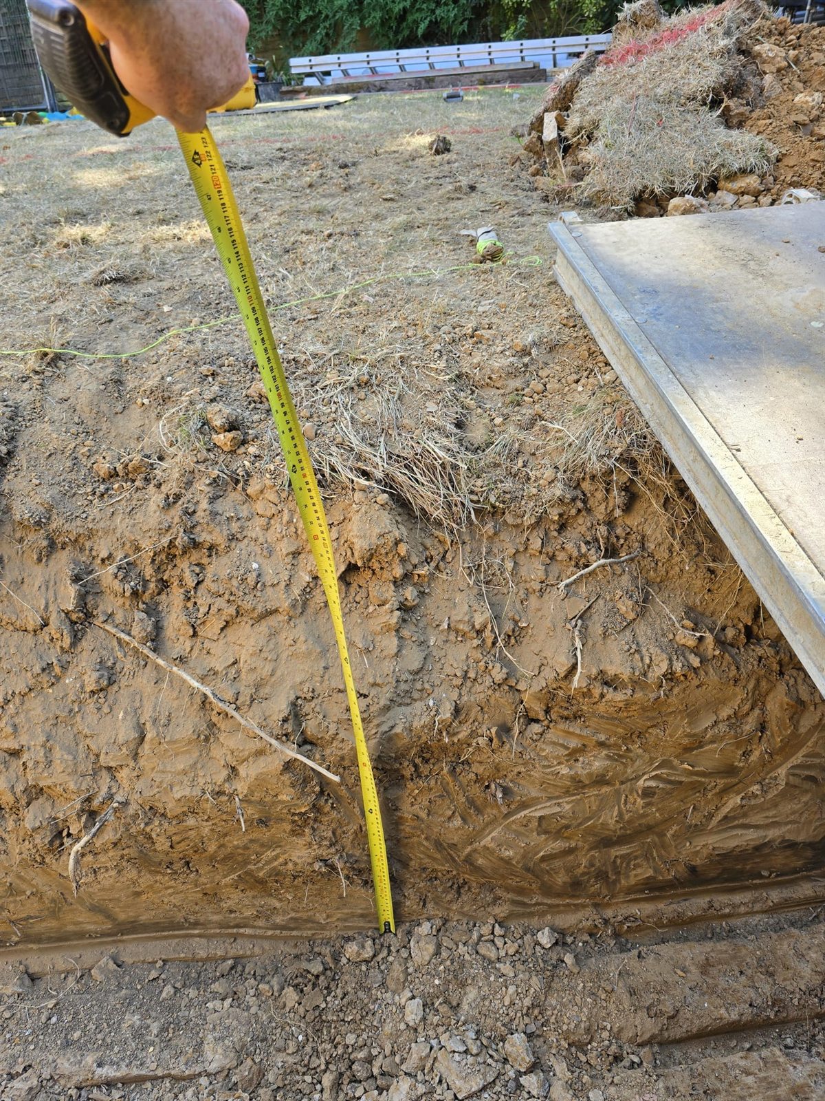 Checking the depth of a foundation trench with a tape measure